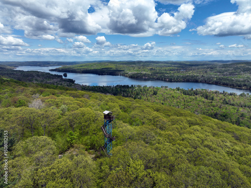 Old fire observation tower on a hilltop in the Laurentians with forest and lakes in the background