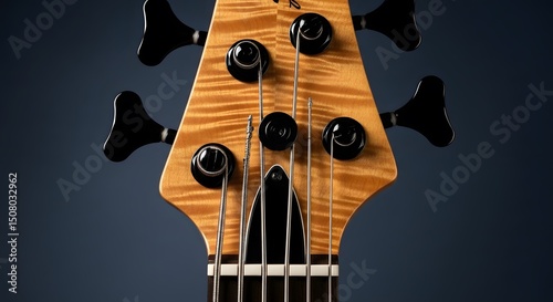 guitar on black background.Exquisite Figured Maple Bass Guitar Headstock Detail.