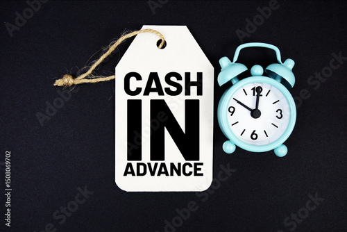 Cash In Advance text on price tag with alarm clock on black background