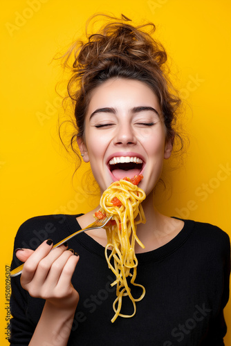 Happy woman eating spaghetti and smiling at the camera