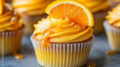 Close-up of an orange cupcake with a slice of orange on top.
