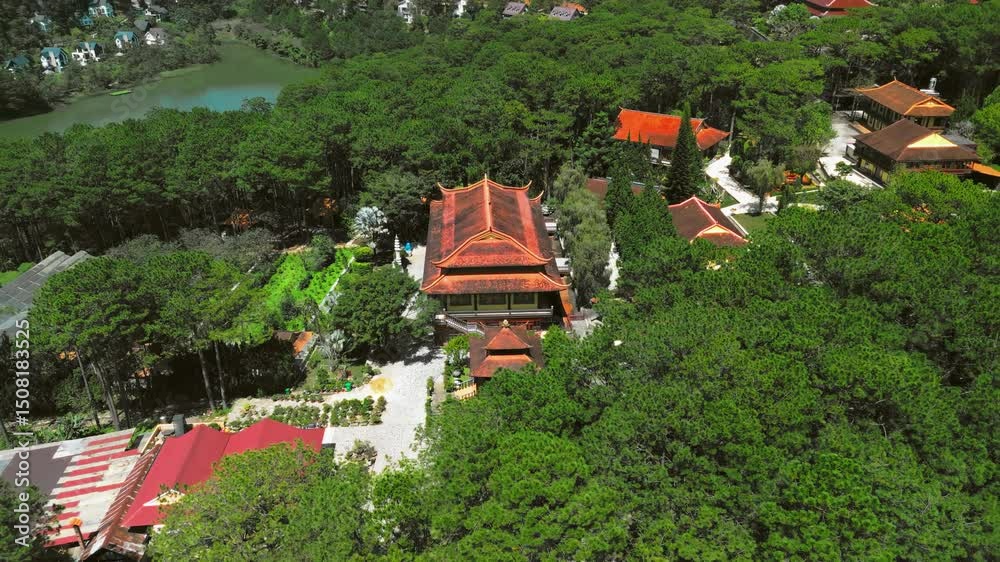 Aerial flyover of the serene Truc Lam Monastery, a Buddhist temple nestled in lush greenery, exuding peace and spirituality. Perfect for cultural or travel projects