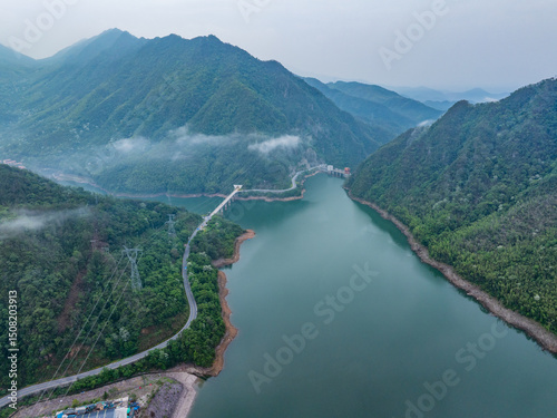 Winding mountain road by a green forest lake