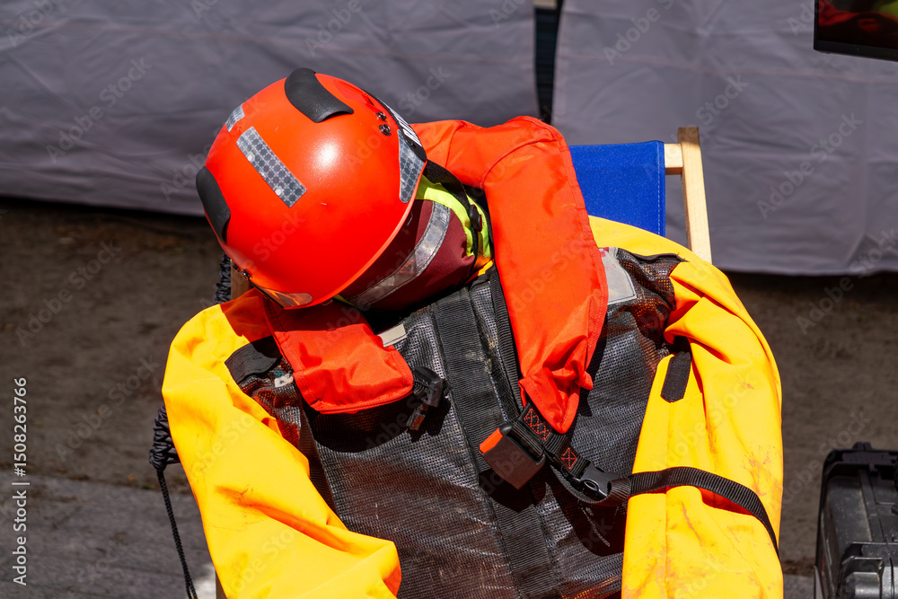 Fototapeta premium training dummy dressed in a safety helmet, life vest, and protective suit used for emergency rescue drills. Shot outdoors in daylight with a tent in the background. Ideal for illustrating safety train