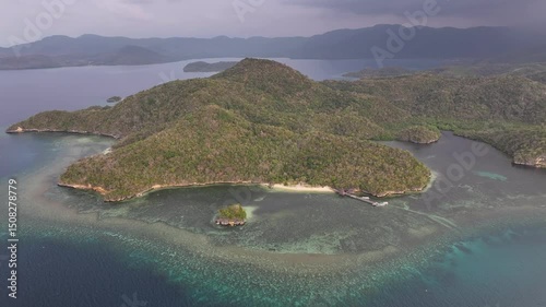 Small beach with pier at Rangko Cave, Labuan Bajo. Tropical coastal with dramatic sky. photo