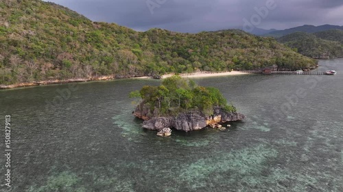 Cinematic aerial over rock formation reveal small beach and tropical remote place of Gua Rangko, Indonesia. photo