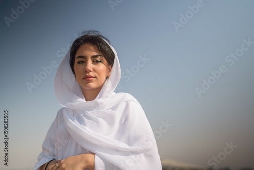 Arabic woman wearing white abaya in the desert
