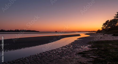 Serene Sunset over Coastal River Estuary Sandy Beach and Silhouetted Trees