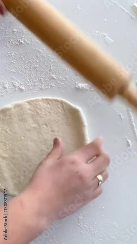 video of the process of making bread or pizza dough using a rolling pin