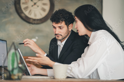 Caucasian Hispanic man discussing work with woman at office desk. male and female working together. Business interaction, teamwork, or small business couple strategic planning work at home office