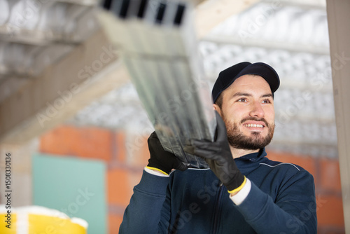 construction worker carrying reinforcement rods at building site