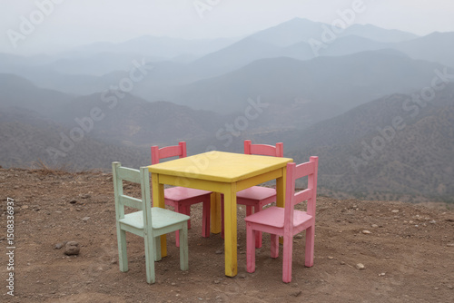 Whimsical pastel picnic set poised on a misty mountaintop, evoking Earth Day serenity and whimsical Dia de Muertos introspection
