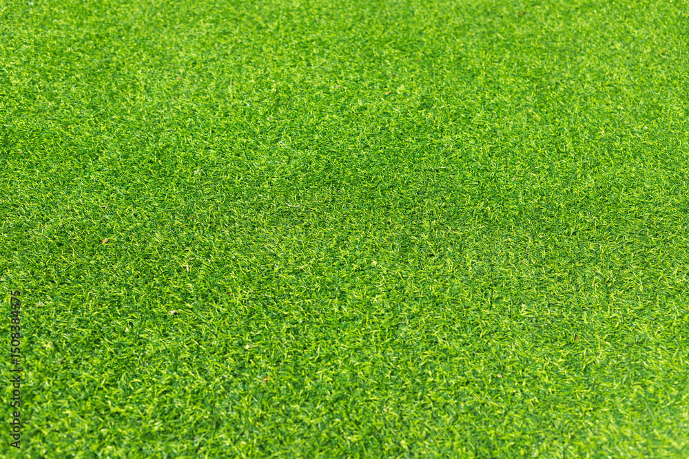 Obraz premium Close-up of lush green artificial grass, showcasing its detailed texture and vibrant color, perfect for outdoor landscaping and sports fields.