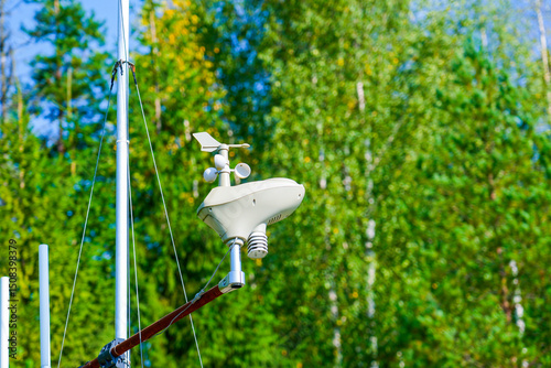 Automatic weather station, with a weather monitoring system, recording and transmitting information remotely observation. Against background forest of green trees leaves photo