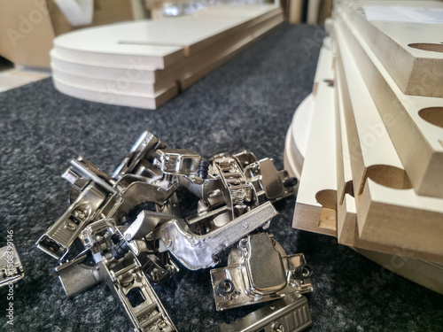 Assembly of furniture components with hardware and cut wood pieces in a workshop setting
