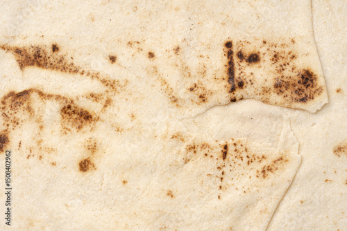 Thin lavash isolated on white background. Armenian unleavened lavash. Lavash as textured bread background.	
