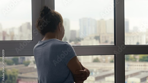 Upset senior female looking out window, suffering loneliness, missing family