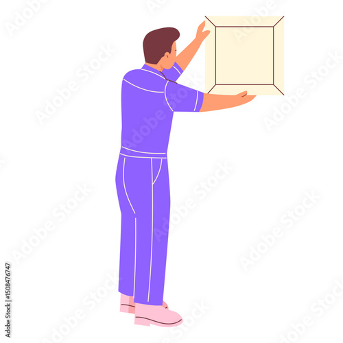 A man in a work uniform hangs a painting on the wall