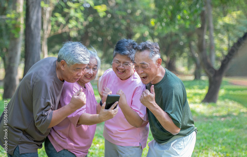 Middle-aged men and women are watching the live broadcast on their mobile phones in a park, smiling happily.