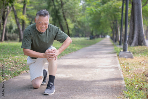 Elderly man experiences knee pain from jogging in a park due to impact or osteoarthritis.