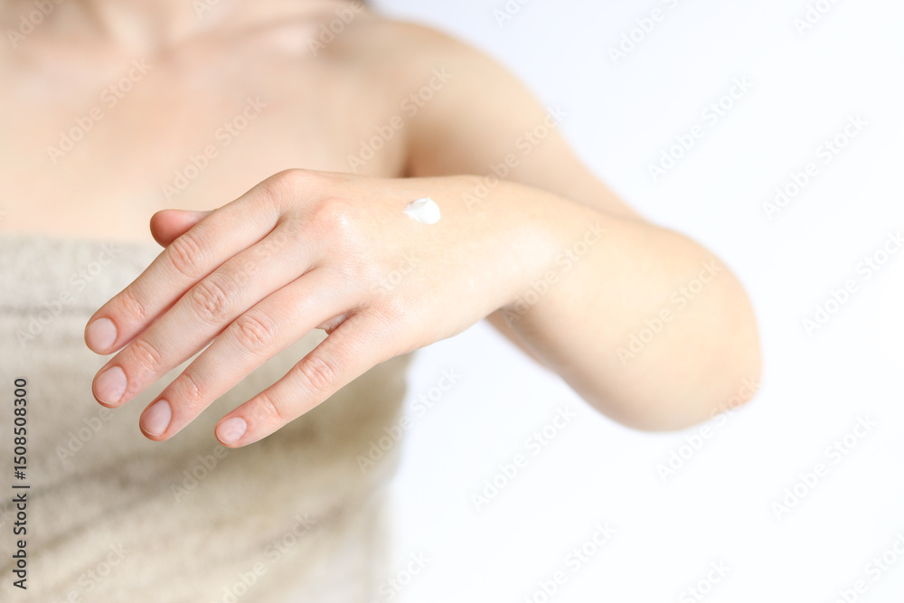 Fototapeta premium Hand cream. Close-up of young woman's hand with moisturizing cream. Skin care. Close-up of female hands applying cream to skin. Healthy skin, skin care concept. Cosmetology. Daily routine