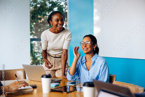 Foto Two women engaging in a lively discussion during a meeting
