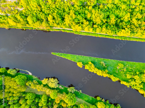 This aerial view showcases the confluence of the Vltava and Labe rivers near Melnik, Czechia, surrounded by lush greenery and vibrant landscapes during a clear day.