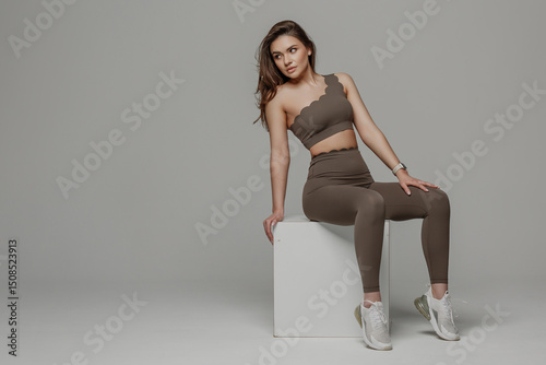 Wallpaper Mural Sporty woman posing in fitness studio wearing fashionable activewear for a stylish fitness shoot Torontodigital.ca