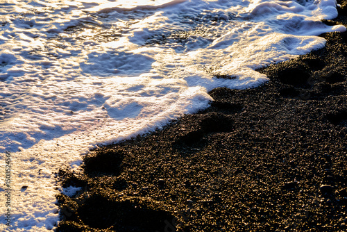 White poem on black sand beach and ocean blue water on evening time in vik , Island , for travel destionation.