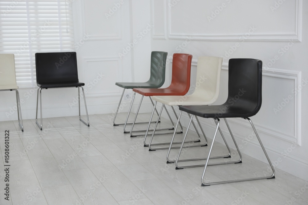 Fototapeta premium Colorful chairs near white wall in waiting room