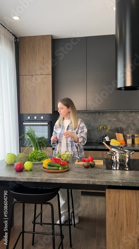 A woman is actively preparing fresh vegetables in her modern and stylish kitchen space