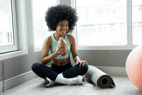 Portrait African American kid girl holding protein shake at fitness gym	