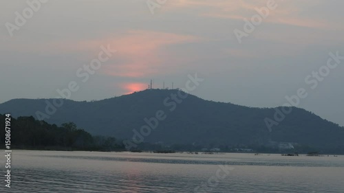 Natural video background of a high-angle atmosphere on a mountain that overlooks the surrounding scenery(mountains, trees,sea)from a scenic vantage point,with a wooden chair for sitting and resting photo