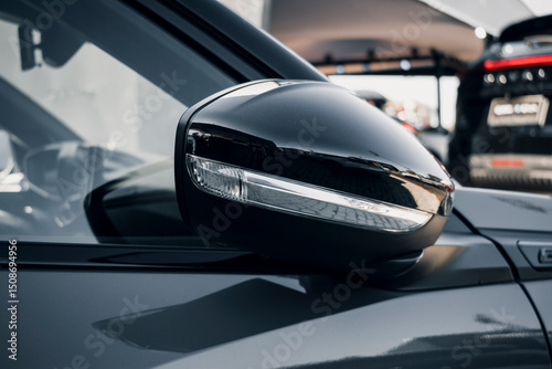 Fotomural A side mirror of a modern car and an integrated turn signal, in a dealership or showroom
