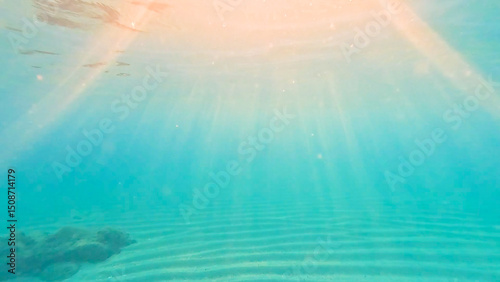 Foto Textured sand sea floor and sun rays penetrate the water.