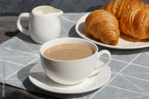 Enjoying fresh coffee and warm croissants on a cozy morning in a serene setting