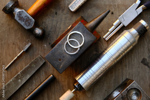 Jeweler's workplace. Top view of jeweler's workbenche with different tools on a wooden table with wedding rings . Goldsmith concept background