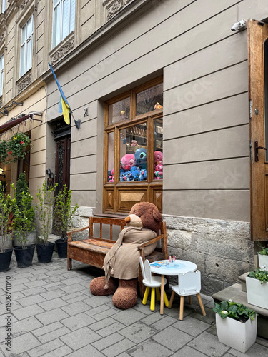 Fototapeta Naklejka Na Ścianę i Meble -  a small teddy bear in a cafe on the streets of Lviv