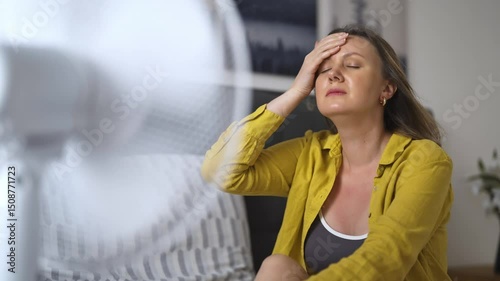 Woman suffering from extreme summer heat indoors.