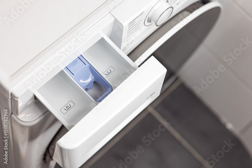 Washing machine detergent drawer close-up in a modern laundry room setting