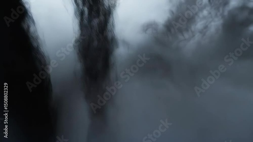 Abstract form of a dark, shadowy figure emerging from indistinct smoky forms, shrouded in ethereal mist and diffused light for a mysterious atmosphere