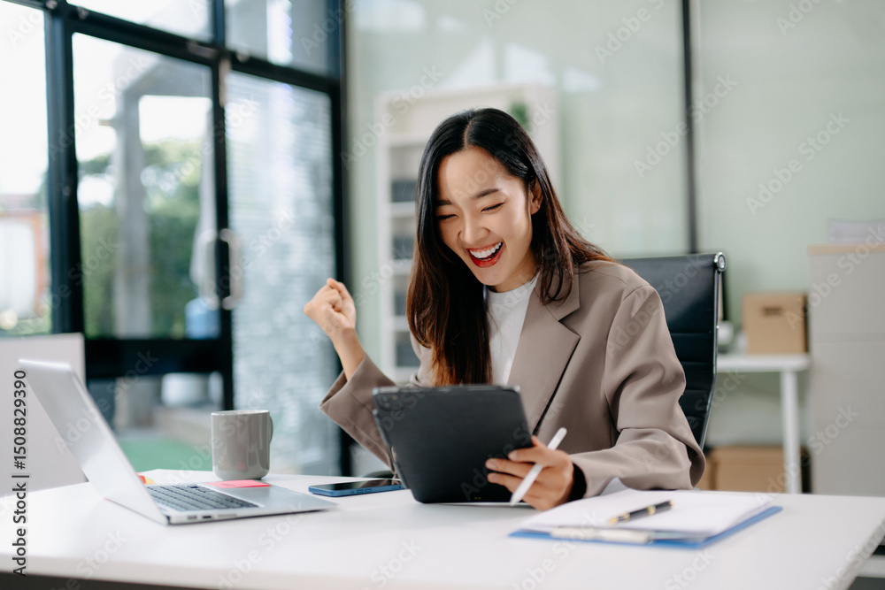 Asian businesswoman at desk using tablet and laptop, celebrating work success and goal achievement. Concept of career growth, joy, and productivity... Asian businesswoman at desk using tablet and laptop, celebrating work success and goal achievement. Concept of career growth, joy, and productivity...