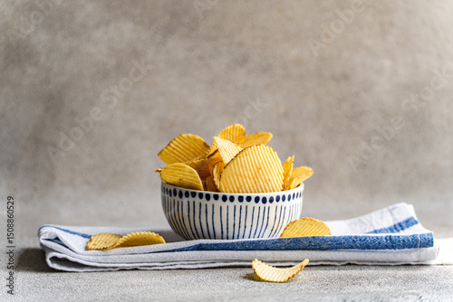 Close-up of a Bowl with homemade potato crisps on a folded tea towel