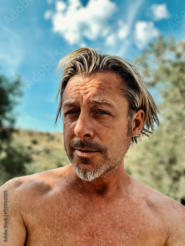 Wallpaper Mural Happy and relaxed shirtless middle aged blond man with stubble beard in sunny outside with lush green vegetation. Torontodigital.ca