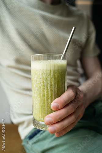 Wallpaper Mural Close-up of a woman in casual clothing holding a green citrus mint smoothie with a metal straw Torontodigital.ca