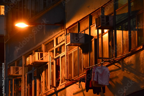 Fototapeta Naklejka Na Ścianę i Meble -  Close-up of the residential building in Hong Kong at night. Building exterior. Hong Kong cityscape, street scene. Travel and cityscape concept.