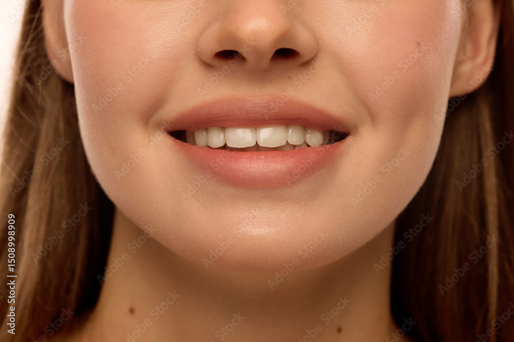 Fototapeta premium Woman smiling with white teeth, natural pink lips, glowing cheekbones and smooth skin. Female model with natural make-up. Concept of dental health, beauty, natural smile, treatment