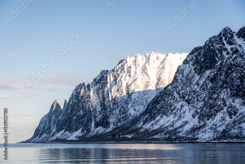 Snow-capped peaks reflected in the crystal-clear waters of Ersfjord