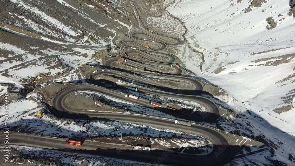 Aérea de Los Caracoles, Chile, mostrando a sinuosa estrada montanhosa rodeada por paisagens áridas e rochosas. Destaque para curvas fechadas e cenário natural típico da região