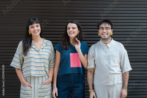 Three friends standing together and smiling warmly